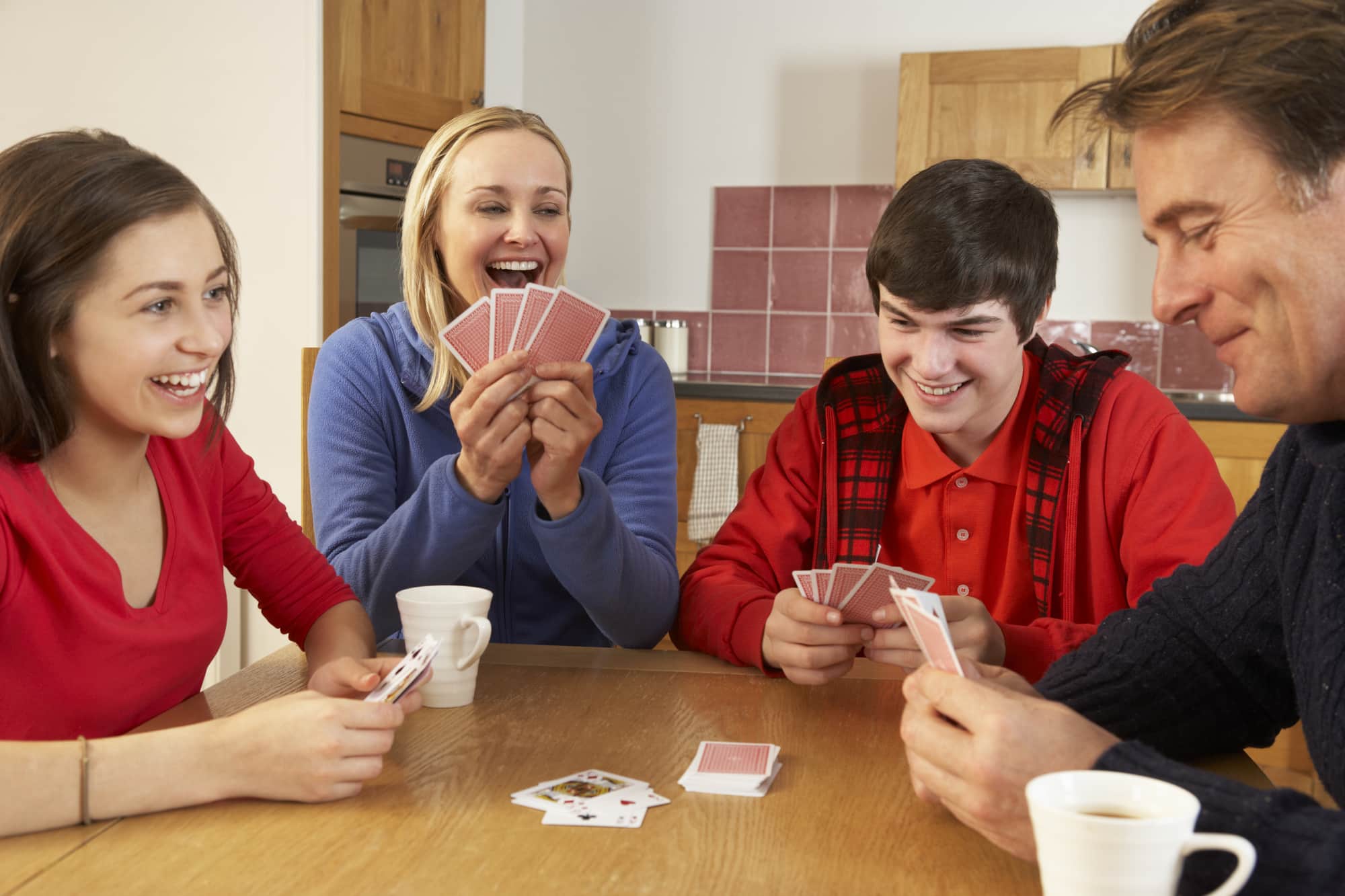 Cards 4 people. Люди играющие за столом. Дети играют в карты. Семья играет в карты. Студенты играют в карты.